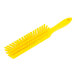 A close-up of a yellow Carlisle Sparta counter brush with a yellow plastic handle and soft bristles.