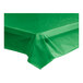 A green plastic table cover unrolled on a table.