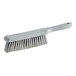 A close-up of a Carlisle Sparta gray soft polyester counter brush with a white handle.
