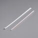Two white plastic straws with red stripes in clear wrapping.