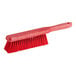 A red Carlisle Sparta counter brush with a long handle.