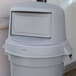 A gray Continental round dome lid on a gray trash can.