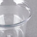 A close-up of a Carlisle clear plastic sauce cup with a lid on it.