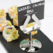 A sushi plate with a Tablecraft stainless steel harp menu holder on it.