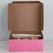 A 8" x 8" x 3" pink bakery box with food inside.