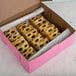 A pink box filled with squares of pastries.