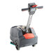 A NaceCare Solutions cordless walk behind compact floor scrubber with a red handle.