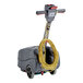 A NaceCare Solutions compact floor scrubber with a yellow cable.