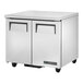 A stainless steel True TUC-36-HC undercounter refrigerator with wheels and two doors.
