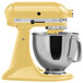 A yellow KitchenAid mixer with a silver bowl.