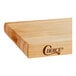 A wooden Choice cutting board with rounded edges and a logo on it.