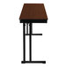 A National Public Seating Montana Walnut wood folding table with black cantilever legs.