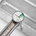 A close-up of the Frymate deep fryer thermometer with a green and white dial.