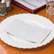 A white plate with a dove gray Hoffmaster paper napkin on it.