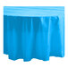 A blue Table Mate plastic table cover on a round table with a white background.