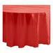 A red Table Mate plastic round tablecloth on a table.