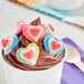 A cup of chocolate ice cream with Vidal assorted color gummy hearts on top.