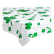 A white plastic Table Mate tablecloth with green shamrocks on a table.