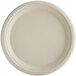 A close-up of a World Centric round white compostable fiber plate with a round edge.