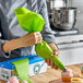 A person using an Ateco biodegradable green pastry bag to frost cupcakes.