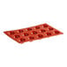 A red silicone Pavoni round baking mold with 15 compartments.