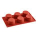 A red silicone baking mold with six round compartments.