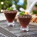 Two Acopa Endure Tritan plastic stemless martini glasses filled with chocolate dessert on a table.