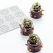 A Pavoni Pavodecor silicone baking mold with chocolate cakes decorated with green leaves.