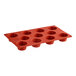 A red Pavoni silicone baking tray with 11 muffin cavities.