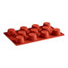 A red Pavoni silicone baking mold with 11 muffin compartments.