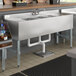 A Regency stainless steel underbar sink with 3 bowls, 2 drainboards, and a faucet.