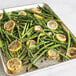 A Nordic Ware sheet pan with asparagus and lemon slices.