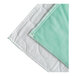 A green and white quilted mattress pad with a white border.