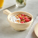 An Acopa Foundations tan melamine soup bowl filled with yogurt topped with berries and nuts.