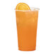 A Tossware plant-based plastic cup filled with orange juice and ice with a slice of orange on the rim.