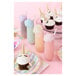 A Tossware plastic champagne flute with a cupcake with a unicorn horn on top.