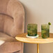 Two Tossware Moss Tritan plastic rocks glasses with green stems on a table.