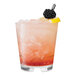 A Tossware Reserve stackable rocks glass with a drink and a blackberry garnish and lemon slice.