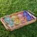 A tray of mint green Tossware Vino glasses on grass.