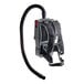 A black and grey Sanitaire backpack vacuum with straps.