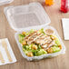 A salad with chicken and croutons in a Genpak clear plastic hinged container.