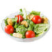 A salad with tomatoes and croutons in an Arcoroc Fleur glass bowl.