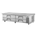 A large stainless steel counter with 4 refrigerated drawers.