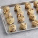 A baking sheet with Otis Spunkmeyer cranberry white chocolate cookies on it.