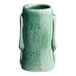 A close-up of a green Acopa ceramic Tiki mug with a handle.