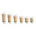 A row of brown Kraft paper coffee cups with white PLA lids.