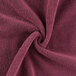 A close up of a burgundy Monarch Brands hand towel.