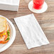 A plate with a sandwich, drink, and Tork Advanced white 1/6 fold dinner napkin.
