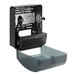 A black plastic Tork electronic hand towel dispenser with a clear lid.