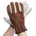 A pair of Cordova Select grain cowhide leather driver's gloves with brown split leather backs on a person's hands.